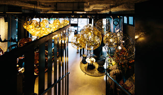 「TOM DIXON SHOP」店内の階段を上ってみると、天井から降りそそぐペンダントライトやシャンデリアの光が幻想的な風景を生み出している。左は「Etch Pendant Brass 32cm」を密集させた展示、右の「Etch Web Pendant」シリーズ