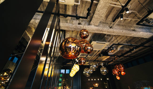 「TOM DIXON SHOP」の店内。エントランスフロアは、ペンダントライトなどの照明の展示が豊富で、「Melt Shade」シリーズ、「Beat Light」シリーズなどが天井に並ぶ