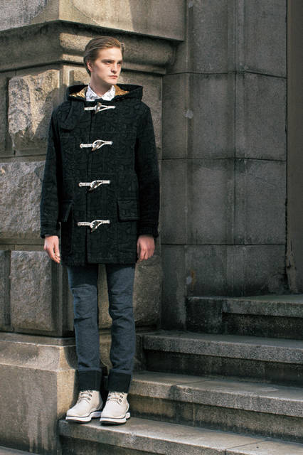 ダッフルコートは、今季のテーマであるネメスのロープ柄をフロッキー加工で あしらったもの。フードから覗く キャメルのライニングとの コントラストも美しく、 ウールとデニムが ニードルパンチで 組み合わされたパンツとのコーディネートもカジュアルながらも気品に満ちた仕上がりとなる。 <br><br>コート88万5600円、 パンツ15万3360円、 シャツ9万9360円、 シューズ19万1160円（ルイ・ヴィトン／阪急メンズ大阪1階）