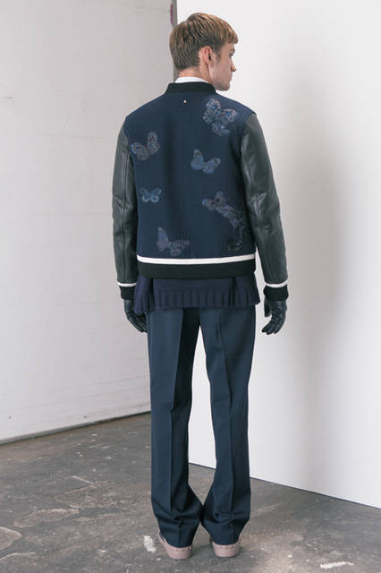 ベーシックアイテムであるスタジャンに、クチュリエの技術を注ぎ込んだバタフライの刺しゅうをあしらい、あたらしいエレガンスを追求。トップスはシャツとオーバーサイズニットをレイヤードし、ボトムスはややワイドなシルエットのドローコード付きパンツでリラックス感を表現。<br><br>  ブルゾン50万7600円、パンツ11万9880円、ニット8万1000円、シャツ6万480円、タイ2万4840円（ヴァレンティノ)<br> グローブ3万4560円、シューズ8万2080円（ヴァレンティノ ガラヴァーニ／阪急メンズ大阪2階、阪急メンズ東京2階）