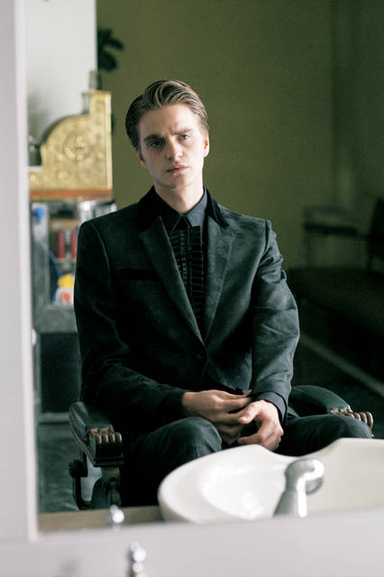 フローラルジャカードのジャケットは共布のパンツと合わせて着用できるセットアップ。シャツは取り外せるレザーのリボンがついたもので、エレガントかつエッジィなドレスアップにふさわしい一枚。全身のフォルムは、コンパクトかつモダンなシルエットに仕上がっている。<br><br> ジャケット30万8880円 ［阪急メンズ限定］、 パンツ11万1240円、 シャツ12万3120円（アレキサンダー・マックイーン／阪急メンズ大阪2階 『ガラージュ D.エディット』、阪急メンズ東京2階）