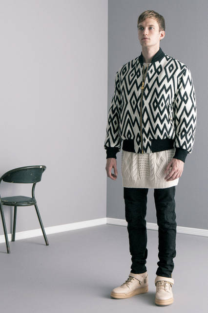 異なる着丈のブルゾンとニットを組み合わせ、レイヤードスタイルを主張。ジオメトリックなパターン使いと クラシカルなケーブル編み、そしてシューレースまでレザーで 統一されたハイカットスニーカーが独自の世界観を色濃く反映。ブラックデニムのバイカーパンツは裾にゴールドのファスナー付き。<br><br>ブルゾン46万2240円、 パンツ12万4200円、 ニット11万5560円、 シューズ20万8440円 ※いずれも阪急メンズ先行販売 8月中旬入荷予定 （ヴェルサーチ ／阪急メンズ大阪3階、阪急メンズ東京2階）