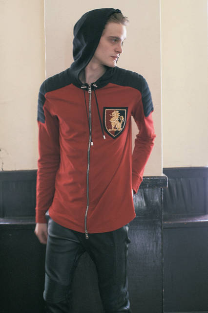 肩に切り替えの入ったパーカは、ショルダーにマトラッセのディテールが入ったバイカラー仕様。胸に配されたエンブレムはインドでハンドメイドによる 刺しゅうが施された貴重なもの。おなじみのバイカーパンツは、タイトなシルエットをストレッチレザーで仕立てた素材使いのセンスが光る。 <br><br> パーカ19万4400円［阪急メンズ限定］、パンツ27万円（バルマン オム ／阪急メンズ大阪2階『ガラージュ D.エディット』、阪急メンズ東京2階）