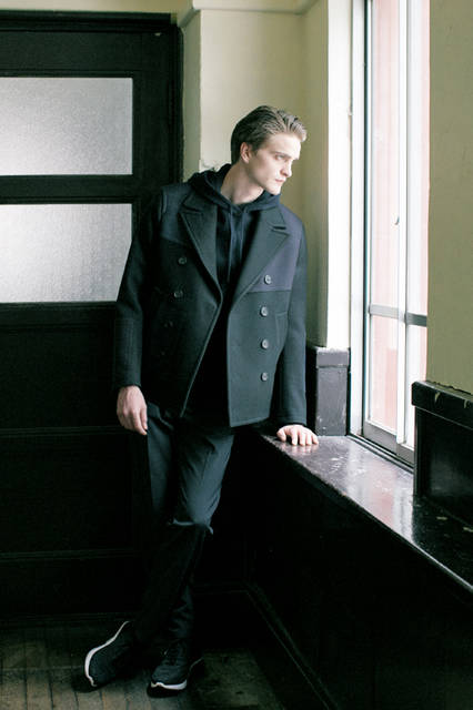 独特なスポーツミックスのセンスが冴える、今シーズンらしいルックの代表例。パッチワークディテールのPコートに、フェルトウールのパーカ、 ボトムスはテクノストレッチ素材のパンツ、そして足元はハイテクスニーカーでスタイリングした現代的なカレッジコーディネートだ。 <br><br> コート24万3000円［阪急メンズ限定］、パンツ7万200円［阪急メンズ先行販売］、パーカ9万3960円［阪急メンズ限定］、シューズ7万9920円［阪急メンズ限定］ （ニール バレット／阪急メンズ大阪2階、阪急メンズ東京2階）