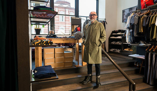 <strong>WORK NOT WORK｜ワーク ノット ワーク</strong><br />2015-16年秋冬コレクションのステンカラーコート（ステンカラー コート ウールライナー）のサンプルを試着する馬場氏