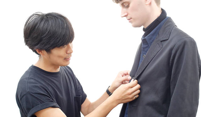 左はスタイリストの壽村太一さん。写真は、東京・大田区のスタジオで行われた撮影の合間の一枚。