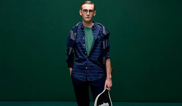 ネイビーに細い白のラインをあしらったボーダー柄のシャツ。ボタンダウンらならではのクリーンなイメージを活かし、スクールテイスト薫る着こなしを。 <br /><br /> シャツ1万6000円、Tシャツ8000円、ニット1万9000円、パンツ1万6000円（すべてラコステ）