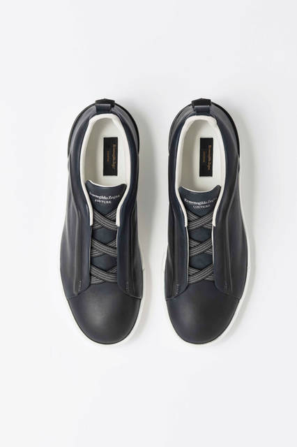 シューレースの部分にアイコンの「トリプルエックス」をあしらったスニーカーは手作業でインディゴ染めがほどこされたもの。ソールは日本製の黒ゴムと白のソールとなっている。靴9万7200円／エルメネジルド ゼニア