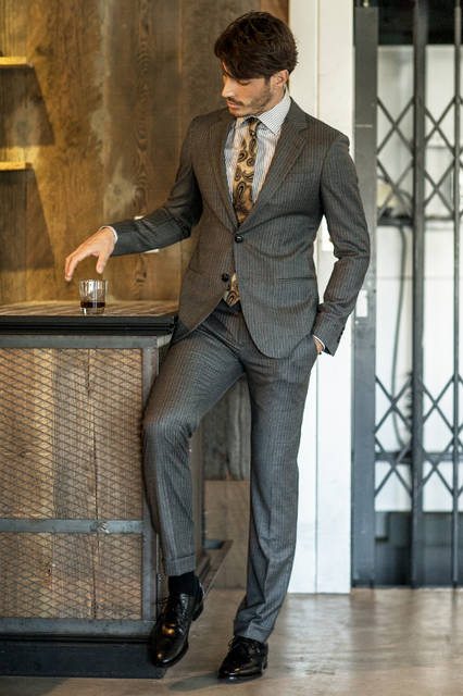 柔らかなイタリアらしい着心地を堪能できるスーツは、クラシックなブラウンのストライプ柄。Vゾーンは同系色のブラウンのペイズリーをあしらったタイでコンテンポラリーにまとめて、大人の風格漂うスタイルに。 <br /><br /> スーツ37万8000円、シャツ6万8040円、タイ2万5920円、ベルト・シューズ参考商品／ジョルジオ アルマーニ＜阪急メンズ大阪3階・阪急メンズ東京3階＞