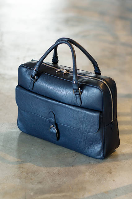 フランスを代表する一流メゾンのOEMを手掛けてきたファクトリーによる、オリジナルコレクション。フラップつきのアウトポケットを備えたこのモデルは、馬具をモチーフにしたディテールや美しい曲線美が優雅な印象。 <br /><br /> バッグ［W41×H29×D9cm］17万2800円／シャンボール セリエ＜阪急メンズ大阪1階・阪急メンズ東京1階＞