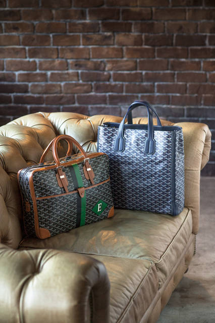 ブランドのアイコンであるヘリンボーン柄を纏った「ゴヤール」は、ビジネススタイルをランクアップさせる名脇役。職人がハンドペイントでイニシャルを描く、マーカージュでパーソナライズすれば、さらに貫禄ある佇まいに。 <br /><br /> 右：トートバッグ［W38×H38.5×D11.5cm］36万5040円、左：ビジネスバッグ［W41×H29×D10cm］36万7200円／ゴヤール＜阪急うめだ本店2階・阪急メンズ東京1階＞