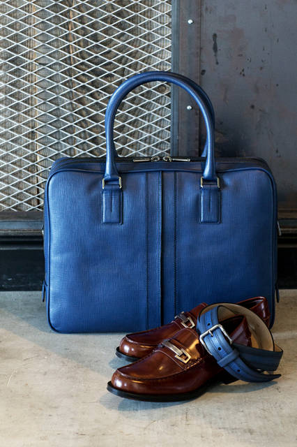 今シーズンの新作となるバッグ、ダブルストライプは「トッズ」が誇るカーフレザーを使用し、リネンのような素材感を演出。ロゴ入りのメタルパーツでスタイルアップしたシューズをコーディネートすれば、洗練されたビジネススタイルに。 <br /><br /> バッグ［W41×H31×D10cm］21万4920円、ベルト4万7520円※9月中旬入荷予定／トッズ＜阪急メンズ大阪3階・阪急メンズ東京1階＞シューズ7万1280円／トッズ＜阪急メンズ大阪3階・阪急メンズ東京3階＞