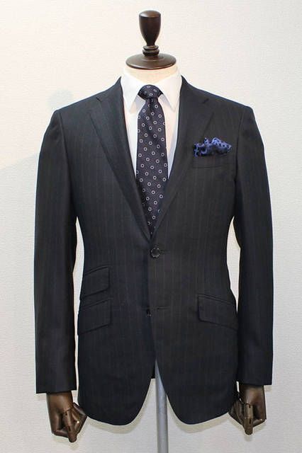 <strong>D'URBAN｜ダーバン</strong><br />2015-16年秋冬コレクション　今季打ち出しのアムンゼン柄に17mmピッチのストライプをのせたスーツは、メインビジュアルでモデルが着用。ネイビーに白ストライプのスーツ、白無地シャツ、ブルーの○柄、ブルーの柄チーフというコーディネート。スーツ10万6920円