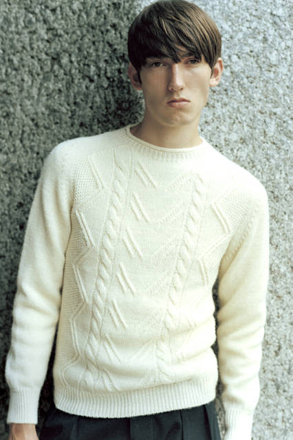 上品な膨らみ感のあるケーブル状の編み目が美しいアランニット。素朴な雰囲気をもつデザインは、適度なフィット感と軽い着心地で、秋を迎えるにふさわしい一枚だ。やや首が詰まっている襟ぐりのデザインにも注目。 ニット3万9960円、トラウザーズ3万5640円（ともにマーガレット・ハウエル）