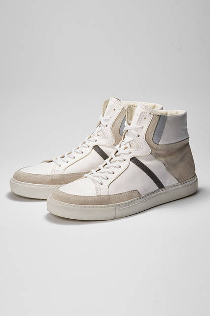 エッジーなカジュアルスタイルに、程よい抜け感を演出してくれるのが白スニーカー。こちらはベージュ、グレー、ブラックといった異なる色を効果的に組み合わせ、ハイカットにデザイン。肉厚なラバーソールとインソールで脚長効果も期待できる。スニーカー7万2360円（ディーゼル ブラック ゴールド）