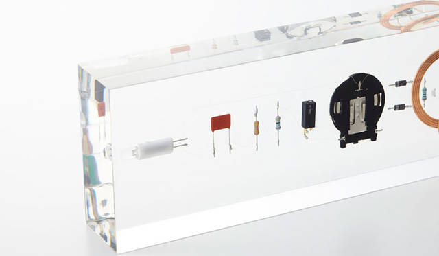 「COMPOSITION」Designed by TAKT PROJECT　木を削り、家具をつくるように、粘土をこね、器をつくるように、素材からシンプルに家電をつくる方法はないだろうか？　異素材を混ぜ合わせてあたらしい素材を生み出すように、電子部品を素材と捉え、外装材となるはずだった樹脂と混ぜ合わせて固める。この複合材は、電気が通る素材であり、電子部品が実際に機能する、プロダクトとして成立した素材でもある。どこまでが素材で、どこからがプロダクトか？　素材からかんがえることで、素材がプロダクトに変わる境界線、そして、それを定義する既存の枠組みについての思索の試作である