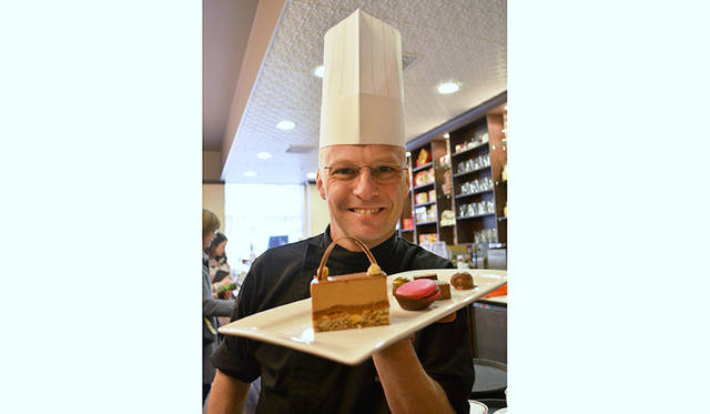 名ショコラティエのアルノー・バックス氏。手にするのは定番人気の「Hazelnut Fan」。極上のヘーゼルナッツにミルクチョコのムースのマッチングは悶絶もの