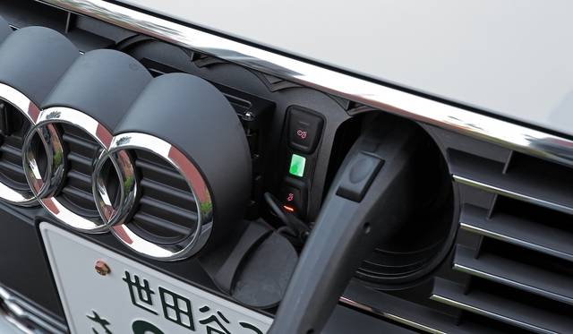 充電口は、フロントのアウディマークをスライドさせるとあらわれる。ソケットは日本仕様なので、既存充電設備の多くで利用が可能だという