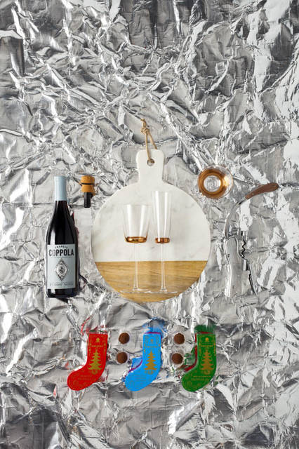 「Christmas 2015 Space」　フランシス・フォード・コッポラ氏のワイナリーで造られる辛口の赤ワイン。いちごやシナモン、落ち葉のような複雑な香りを持ったエレガントな飲み口「Pinot Noir Monterey」3888円、シャンパン用ボトルストッパー「Bubble Cork」7344円、大理石とマンゴーウッドの組み合わせがパーティーシーンで洗練されたテーブルトップを演出するチーズボード。ザ・コンランショップオリジナル「Marble & Mangowood Cheese Board」（30cm）1万3824円、ローズゴールドのラインが華やかなグラスシリーズ「Edge White Wine Glass」、「Edge Champagne Flute」、「Edge Tumbler」すべて価格未定、フランスの老舗ワインツールメーカー「L'Atelier du Vin（アトリエ・デュ・ヴァン）」のワインオープナー「Oeno Box」2万520円、ロンドンの老舗チョコレートブランド「PRESTAT（プレスタ）」のクリスマス限定トリュフチョコレート（4粒入り）。左からヘーゼルナッツプラリネ、塩キャラメルダークチョコレート、シャンパンミルクチョコレート「Stocking Chocolates」各1998円