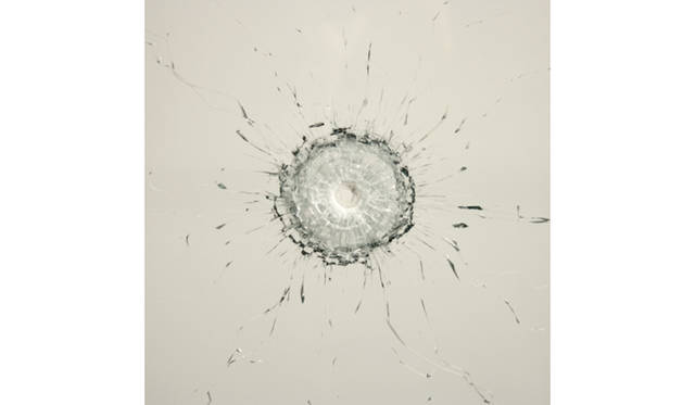 オノ・ヨーコ「穴」2009 年、弾の貫通した板ガラス、刻印されたテキスト「ガラスの反対側に廻り、穴から覗く」、金属の枠（部分）、個人蔵　©YOKO ONO 2015