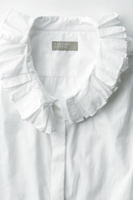 襟元のダブルラッフルがエレガントなシャツ。第一ボタンを外し、リラックスフィーリングで着こなすのがおすすめ。シャツ3万4560円