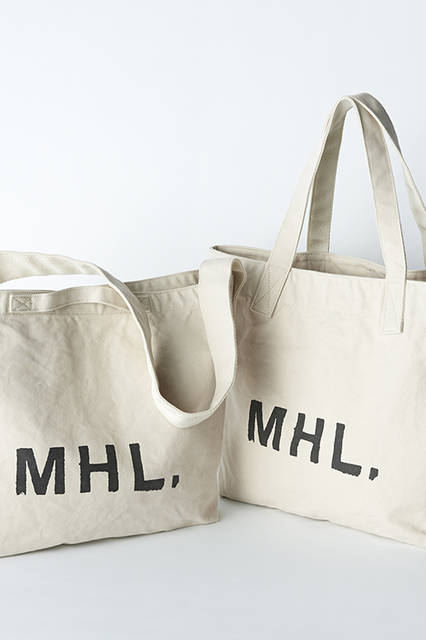 シンプルななかにこだわりを凝縮させた定番のロゴバッグ。 ベーシックなアイボリーカラーのヘビーキャンバス製だから、性別やスタイル、シーンを問わず幅広く使いこなせるのが魅力。左から、2WAYバッグ1万800円、トートバッグ1万800円 （メンズ、ウィメンズ共通）