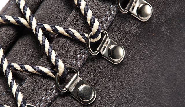 シューレース部分はレースを素早く着脱できる、本格派の可動式Dカン及びフック仕様。登山用ブーツも採用する実用的スペックであり、靴を頻繁に脱ぎ履きする日本の住環境にも敵う。またモノトーンの色使いに金属的な質感が都会的なアクセントにもなっている。