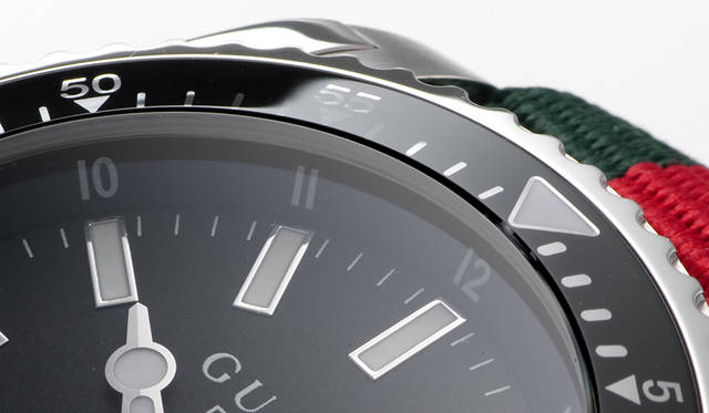 風防の外周部分をよく見ると、ベゼルの上にブラックカラーのガラスが配されている。美しい外観を意識したグッチの細かな配慮だ<br /><br /><strong>グッチ ダイヴ</strong><br/>ケース｜ステンレススチール<br/>直径｜45mm<br/>ムーブメント｜クォーツ<br/>防水｜20気圧<br/>ストラップ｜ナイロン製NATOストラップ<br/>機能｜逆回転防止ベゼル<br/>価格｜12万9600円
