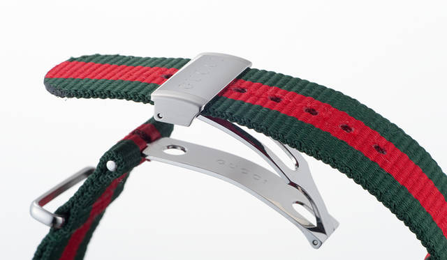 グリーン・レッド・グリーンのウェブ ストライプもグッチの世界を表現するデザインワークのひとつ。ナイロン製ながら高級なフォールディング バックルを装備し、使い勝手にも配慮がなされている<br/><br/><strong>グッチ ダイヴ</strong><br/>ケース｜ステンレススチール<br/>直径｜45mm<br/>ムーブメント｜クォーツ<br/>防水｜20気圧<br/>ストラップ｜ナイロン製NATOストラップ<br/>機能｜逆回転防止ベゼル<br/>価格｜12万9600円