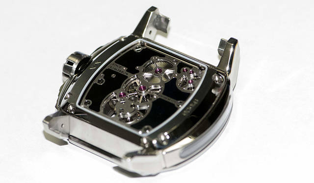 トゥールビヨンと主要歯車がセットされている位置をスケルトンにしたケースバック。地板のマットブラックは最高級のエナメル仕上げ<br /><br /><strong>Reflect Tourbillon｜リフレクト・トゥールビヨン</strong><br />ケース｜チタン<br /> サイズ｜縦48×横52×厚さ12.5㎜<br /> ムーブメント｜自社製手巻き（Cal.DC261）<br /> 振動数｜2万1600/時<br /> 石数｜27石<br /> パワーリザーブ｜約95時間<br /> ストラップ｜クロコダイル<br /> 防水｜5気圧<br /> 限定数｜9本<br />価格｜3024万円(予価)<br />