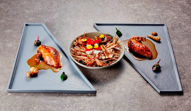 <strong>絆／メイン（肉）</strong><br>夫婦の象徴とされている鳩。つがいとなり二人三脚で人生の旅を楽しんでゆく様子を表現した料理。食べやすくクセのないフランス産の上質な肉質の鳩を、“実りの恋”の花言葉を持つ無花果の葉のオイルを香らせながら炭火でグリルし、不老長寿を願う縁起物のちょろぎを付け合わせに添えた。もも肉は春菊のピューレをアクセントに栄養素の高い黒にんにくとピスタチオをあしらい、二つのもも肉を赤い糸で結び夫婦円満を表現。