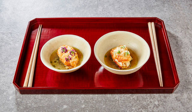 <strong>夫婦／温前菜</strong><br>食卓を夫婦茶碗で分かち合う喜びの時間を表現。旬の白子のムニエルを、大きさが異なる二つで一つの対になっている縁起の良い夫婦茶碗で召し上がっていただく一品。また、鱈の白子には”鱈腹(たらふく)食事ができる”という日本ならではの縁起の良い食材という言い伝えも。