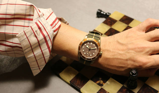 バーゼルワールド2018で発表された「GMT」は、1950年代製のダイバーズウォッチにインスピレーションを得たデザイン。チューダーが製造するキャリブレーションに新しい機能を導入した自社製のキャリバーMT5652を採用している。GMTの象徴ともいえるバーガンディとブルーの２色のベゼルは、時差を超えて世界を飛び回るエグゼクティブにぴったりなデザインとして人気だが、あえてカジュアルな装いに自然となじませた。「スーツにGMTって、一昔前はすごくイメージがあったけど、チューダーはクラシックだし、今の時代ならもっとラフに使いこなすほうが粋では。これは村上さんから撮影前に「着てみたい」と逆指名を受けた＜ヤンチェ_オンテンバール＞のチェックコート。鮮やかな＜マルニ＞のニットとロングマフラーも、カジュアルを意識しました。ベゼルと同配色のNATOストラップにすることで、ステンレスのブレスよりも全体を落ち着かせてみました」。