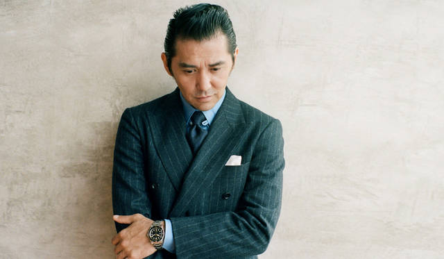 チューダー初のダイバーズウォッチが登場した1958年をネーミングに冠した「フィフティエイト」。ブラックのダイヤルとゴールドの針やインデックスのコンビはラグジュアリーな印象を与えつつ、50s特有のミッドセンチュリーなムードを匂わせている。そして、39mmのケース径はその他のモデルに比べるとやや控えめな印象。そこで今回は、あえてスーツに合わせてみた。「ダブルのスーツにコーデュロイのモンクレールのダウンで、ドレスとカントリーのミスマッチを楽しんでみました。そこに「フィフティエイト」が加わると、そのままSUVに乗って郊外へ行きたくなる、そんなカジュアル感が出ますよね。グレーのスーツの場合、白シャツよりもサックスブルーが雰囲気に合っている。タブカラーを外した遊び心も小さなポイントです」。12時位置に配されたレッドポイントもレトロを感じるディテールのひとつ。<br>ファー付きブルゾン33万4000円（モンクレール／モンクレール ジャパン 03-3486-2110）スーツ15万円（ソブリン／ザ ソブリン ハウス 03-6212-2150）シャツ1万3000円（ユナイテッドアローズ／ユナイテッドアローズ 六本木ヒルズ店 03-5772-5501）※ネクタイはスタイリスト私物