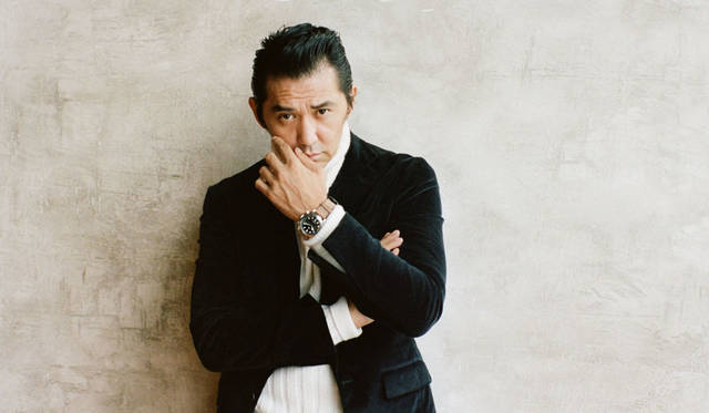 2017年のバーゼルワールドで発表された「クロノ」はやや厚めのケースが男らしさに気品を添える。クラシックな針のデザインと、ドットのインデックス、そしてモダンな2メーターのクロノグラフによる絶妙なコンビネーションがアイデンティティ。シンプルな中にもチューダーの新旧の魅力が詰まったデザインだ。「村上さんは大のライカマニア。今回の撮影のために真っ白な私物のM8を持参してくれたんです。と、いうわけでこのスタイルのテーマは「フォトグラファー」。クロノグラフって、僕の中で硬派なイメージなだけに、普段使いするとかえってファッション性が強く見えるんです。そこらへんが勝手にイメージしているフォトグラファー像（笑）。今回は茶色のレザーベルトを選んで、あえて裏返した＜ロエベ＞のムートンや足元の革靴と色を合わせてみました。もちろん白のタートネルネックニットは、M8とリンクしています」。<BR>シアリングコート59万円（ロエベ／ロエベ　ジャパン カスタマーサービス 03-6215-6116） スーツ17万円（CARUSO × TOMORROWLAND／トゥモローランド 0120-983-522） タートルネックニット4万2000円（アミ アレクサンドル マテュッシ／アミ オモテサンドウ 03-5778-4472）シューズ11万5000円（J.M. WESTON／ジェイエムウエストン 青山店 03-6805-1691）