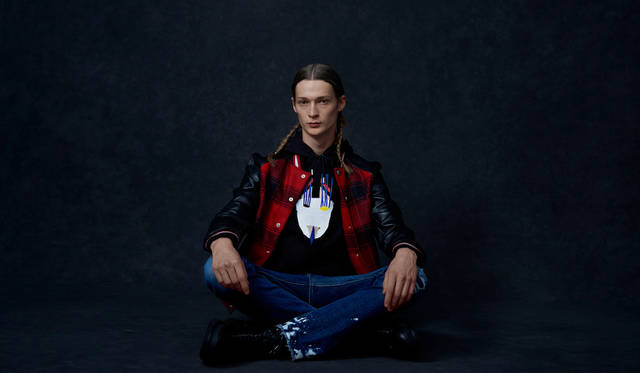 「グラフィカルなパーカにバッファローチェックのスタジャンを羽織ったアメリカンカジュアルなスクールボーイ風の着こなしです。ブルージーンズとブーツを合わせてどことなくグランジロックなテイストもプラス」レザージャケット15万4000円、パーカ2万9000円、デニムパンツ4万1000円、シューズ6万3000円（すべてディーゼル ブラック ゴールド）